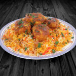 Halal chicken kofta and rice dish over dark wood panels